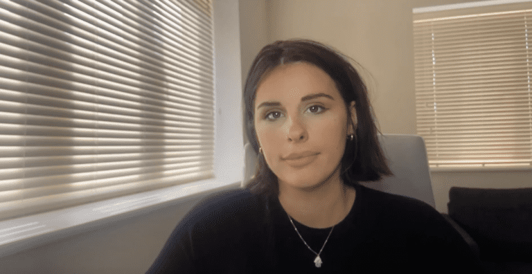 A woman is sitting in front of a window midjourney.