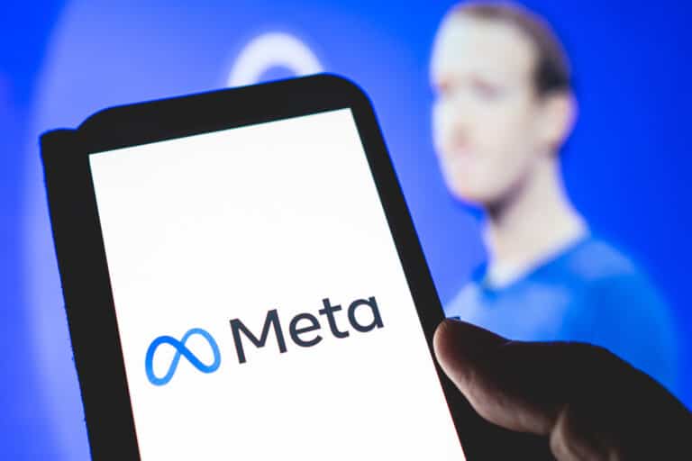 A person unveils revolutionary plan to change social media with AI personas and holds up a smartphone with the meta logo.
